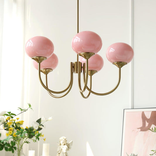 Elegant LichtWolk Marshmallow Luchter met vijf roze glazen bollen en een gouden armatuur, hangend in een stijlvolle kamer. Deze luxe hanglamp voegt een vleugje vrouwelijke charme en verfijning toe aan elk interieur, perfect voor woonkamers, eetkamers of slaapkamers.